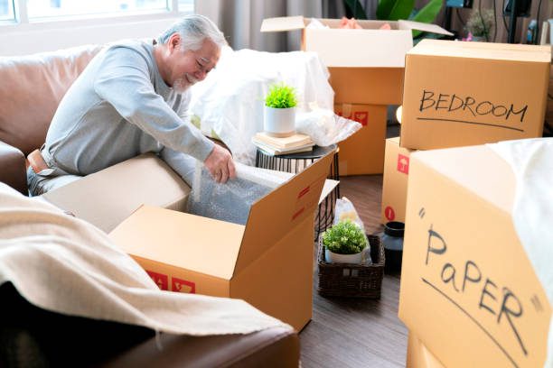 NuWay Relocation | Senior Moving Services: From Downsizing to Settling Into a New Home Senior moving specialist helping an older adult pack belongings for a move